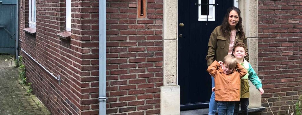 moeder met kinderen voor haar huis waarvoor ze een hypotheek heeft geregeld via WOONregisseur