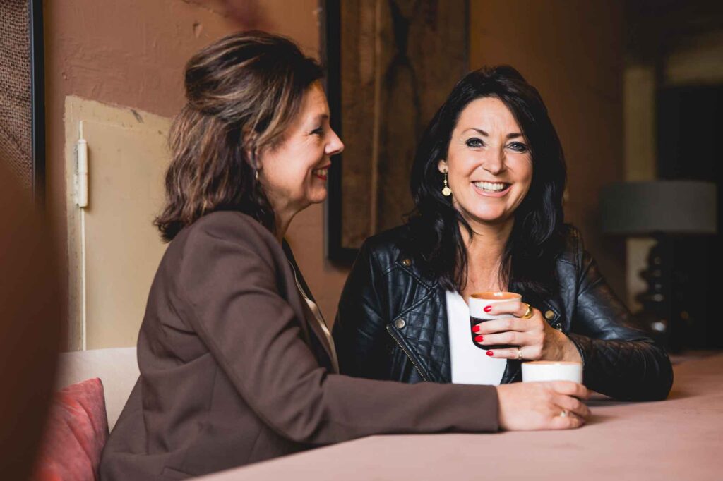 woonregisseurs claudia en collinde overleggen en drinken koffie